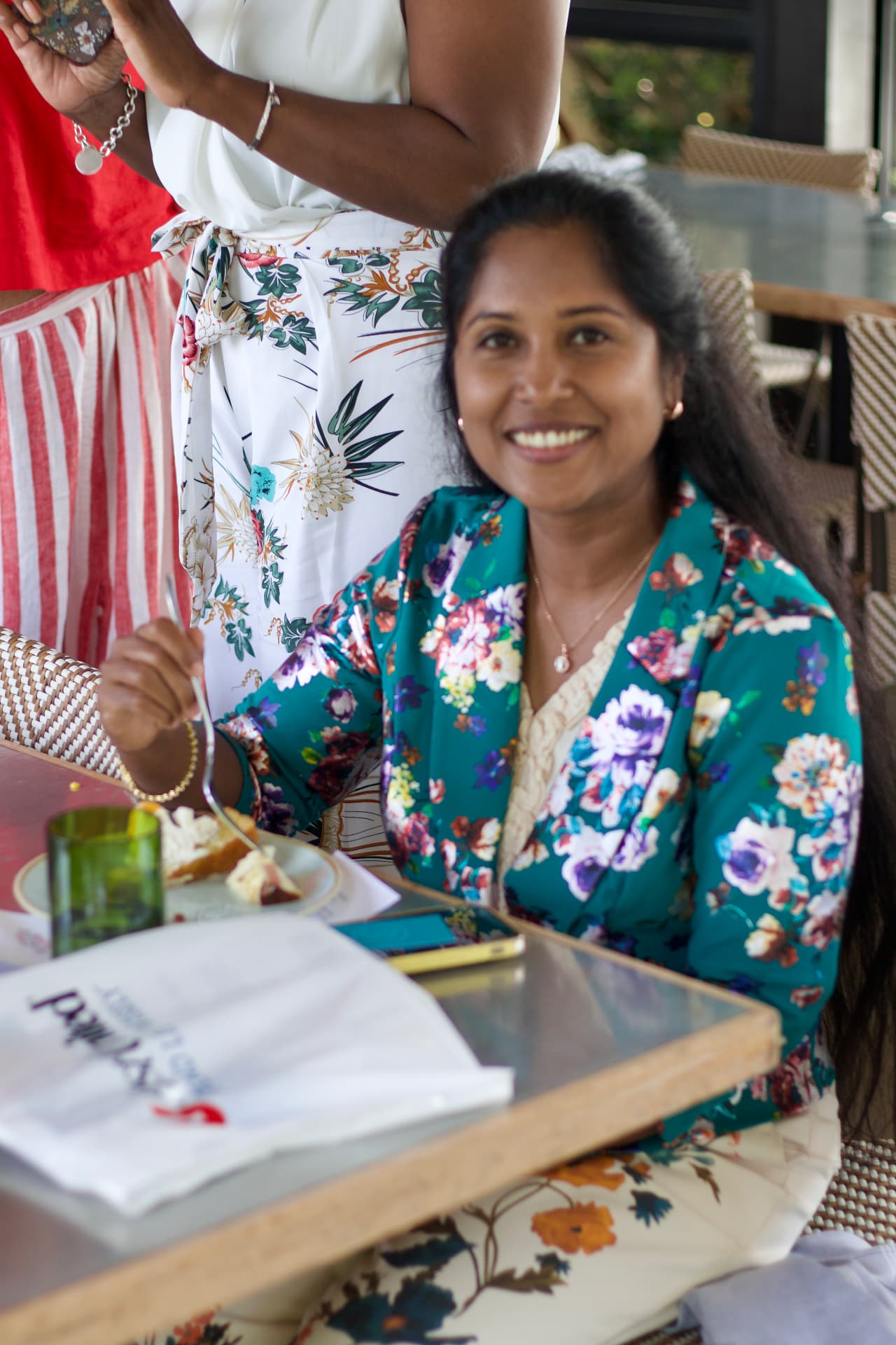 A guest smiling at her table during lunch at Sixty Vines